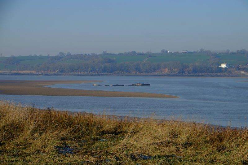 With the remains of the boats which destroyed the old bridge visible at  low tide