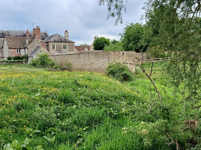 Historic village with field and stone bridge view.
