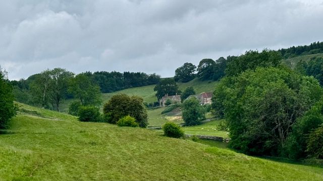 Countryside landscape with rolling hills and trees.
