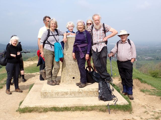 Group of hikers at hilltop monument.