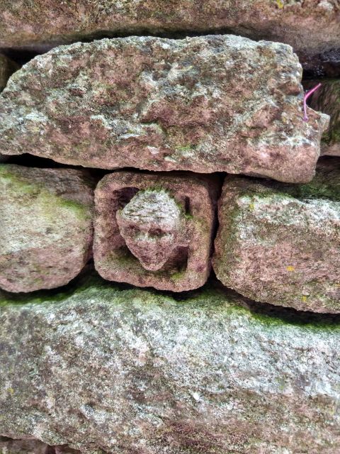 Stone wall with carved face detail.