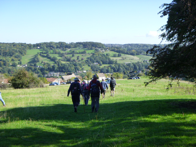 Group walking towards scenic countryside view.