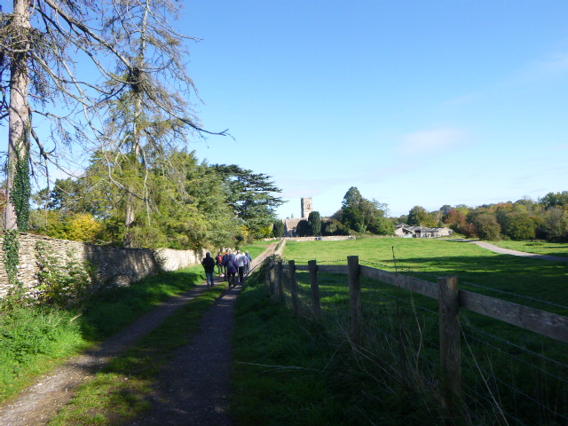 Countryside path towards church on sunny day.