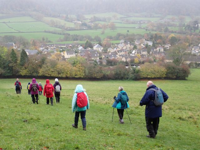 Group hiking towards English village in countryside