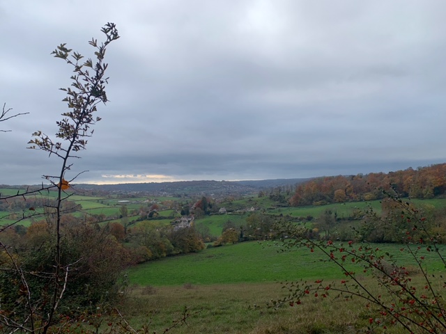 Overcast countryside view with rolling green hills.