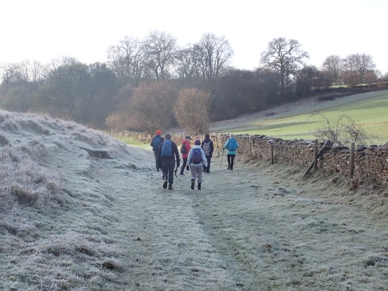 Group hiking on frosty countryside path