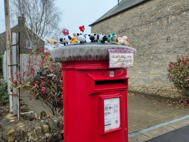 Decorated red postbox with knitted figures